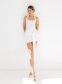 Modelka w kremowym body Melia z dekoltem caro oraz drapowanej mini Cassia z szarfą