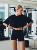 Krótki fason czarnego topu After Class sięgający talii na sylwetce modelki