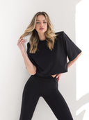Zbluzowany czarny T-shirt Kaia ściągnięty w talii, zestawiony z ciemnymi spodniami