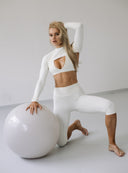 Modelka w kremowym bolerku Comfy Vanilla, dopasowanym topie oraz jasnych legginsach