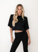 Czarny T-shirt Kaia ze zbluzowanym dołem i poduszkami w ramionach na modelce