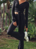 Czarne legginsy Flare Deep Black w stylizacji z wiązanym topem i jasnymi sneakersami